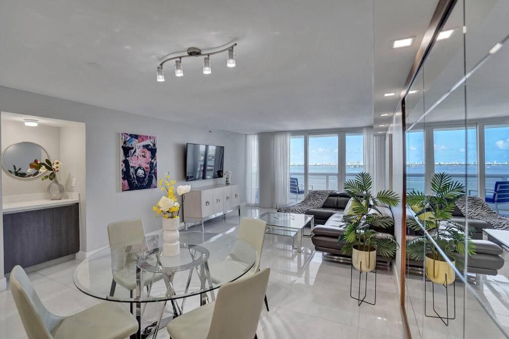 a living room with a glass table and a couch at A Wave From It All! Direct water views! in Miami