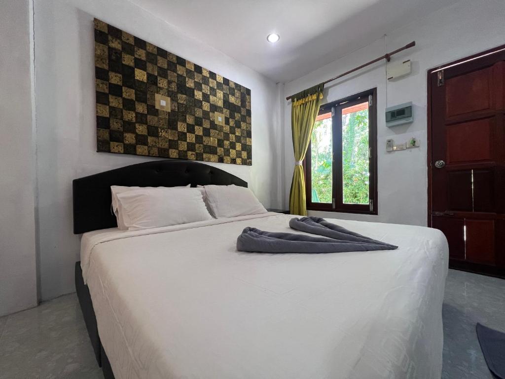 a bedroom with a large white bed and a window at Pakmeng Beach Resort in Pak Meng