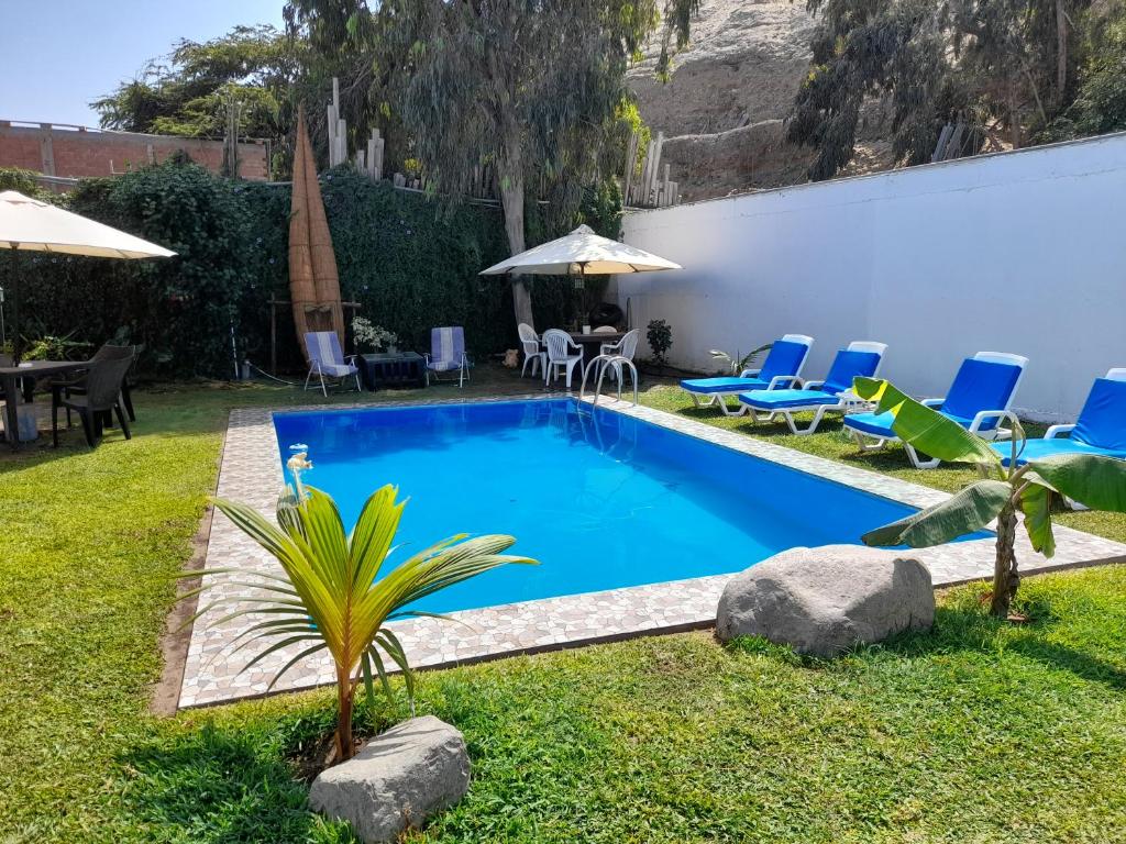 萬查科的住宿－Montemar Apart Hotel - Playa Huanchaco，庭院内的游泳池,配有椅子和遮阳伞