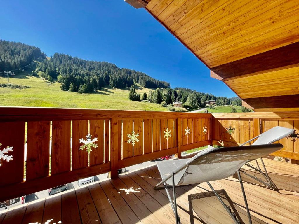 a balcony with a chair on a wooden deck at Appartement Notre-Dame-de-Bellecombe, 3 pièces, 4 personnes - FR-1-505-190 in Notre-Dame-de-Bellecombe