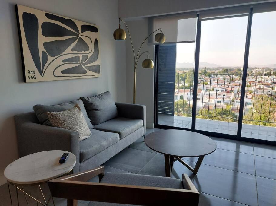 sala de estar con sofá y 2 mesas en LIVA depa Solares @serra, en Guadalajara