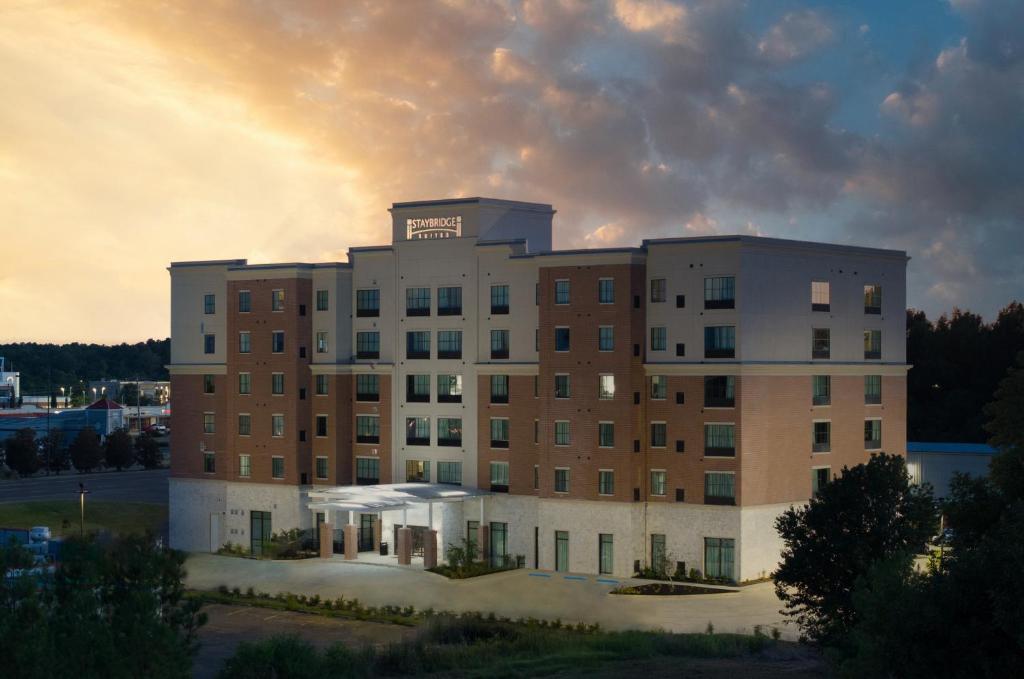 a large building with a sunset in the background at Staybridge Suites - Flowood - NW Jackson, an IHG Hotel in Flowood