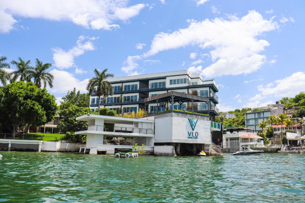 un edificio sobre el agua frente a un edificio en Vlú Hotel Tequesquitengo, en Tequesquitengo