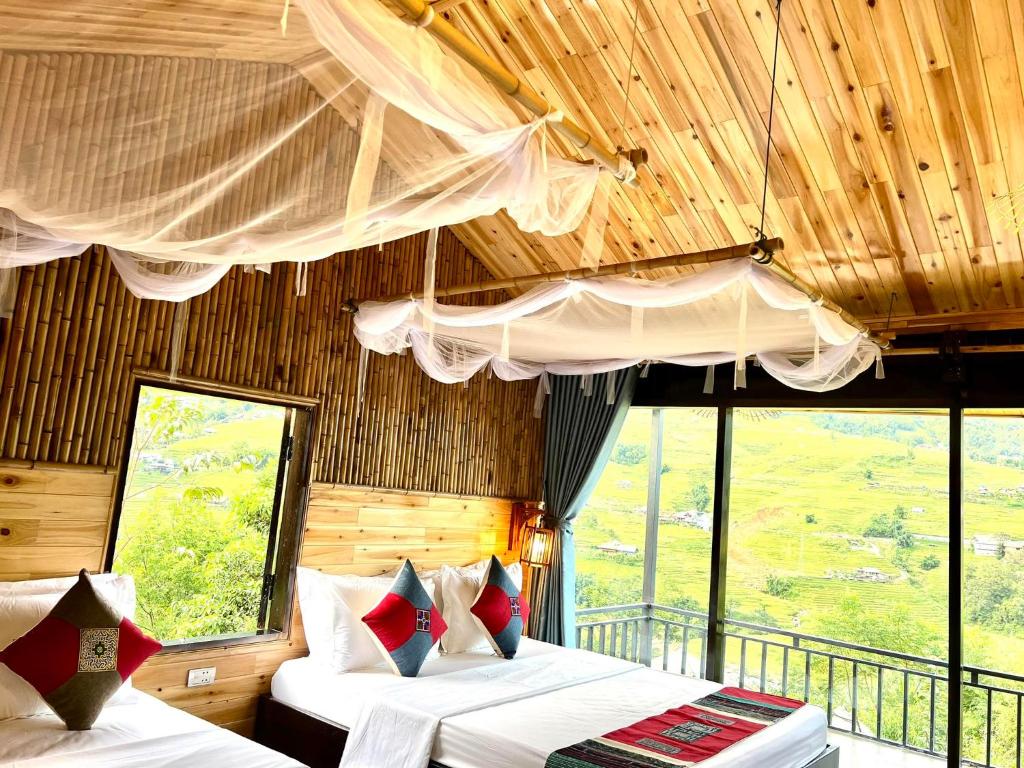 - une chambre avec 2 lits dans une pièce avec fenêtres dans l'établissement Hmong house Sapa, à Sa Pa