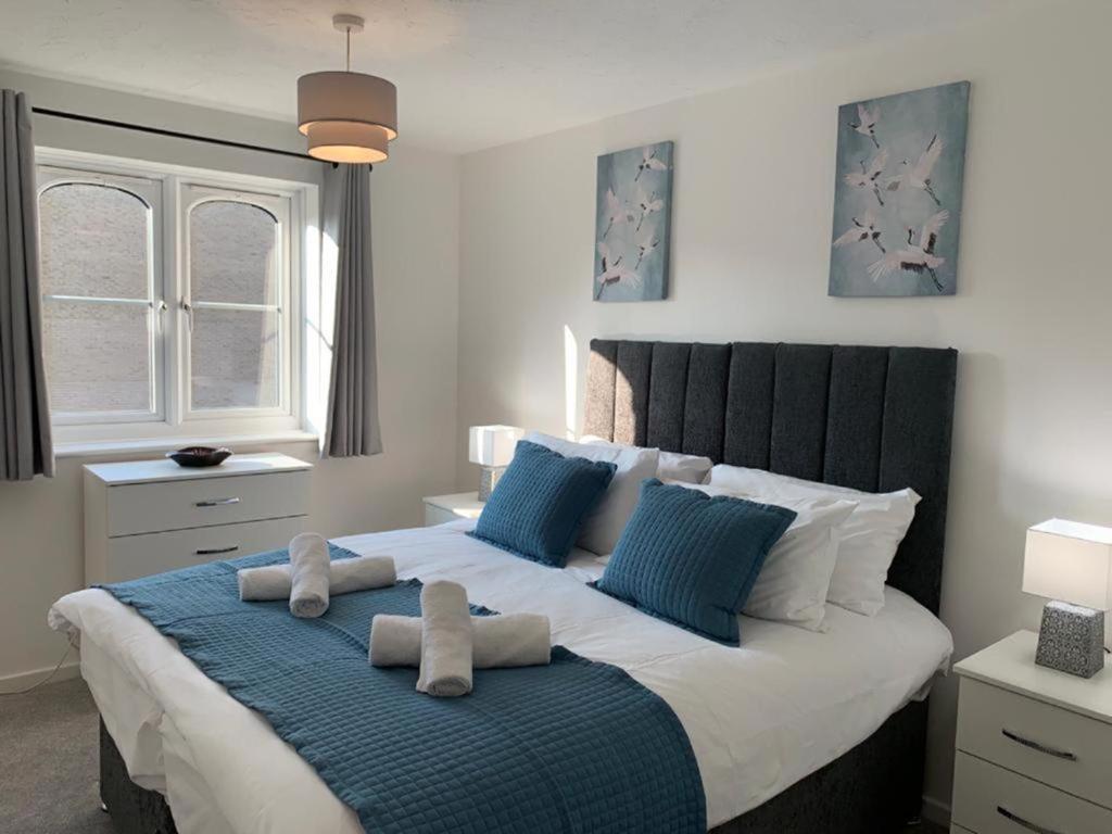 a bedroom with a large bed with two towels on it at Watford Gemini - Thanet House, Nr Watford Metropolitan, M1,M25 in Watford