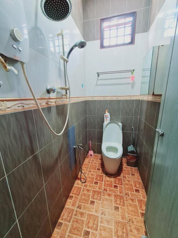 La salle de bains est pourvue d'une douche et de toilettes. dans l'établissement Homestay Nukman Bukit Besi, à Dungun