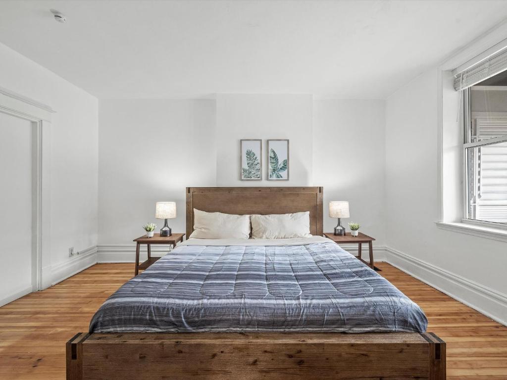 um quarto com uma cama grande e duas mesas em Oakland/University @A Spacious & Modern Private Bedroom with Shared Bathroom em Pittsburgh