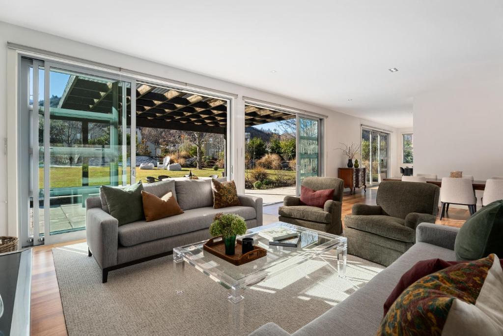 a living room with couches and a table at Kinsale - Spa, Pool, Gym and Tennis! in Arrowtown