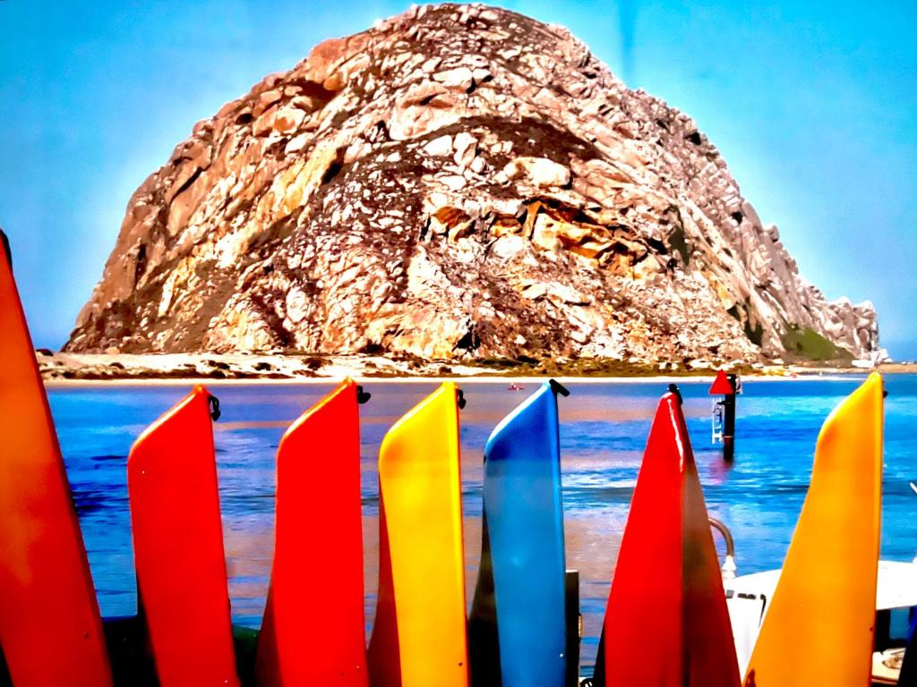 a group of colorful surfboards in front of a mountain at Morro Bay Beach Inn in Morro Bay