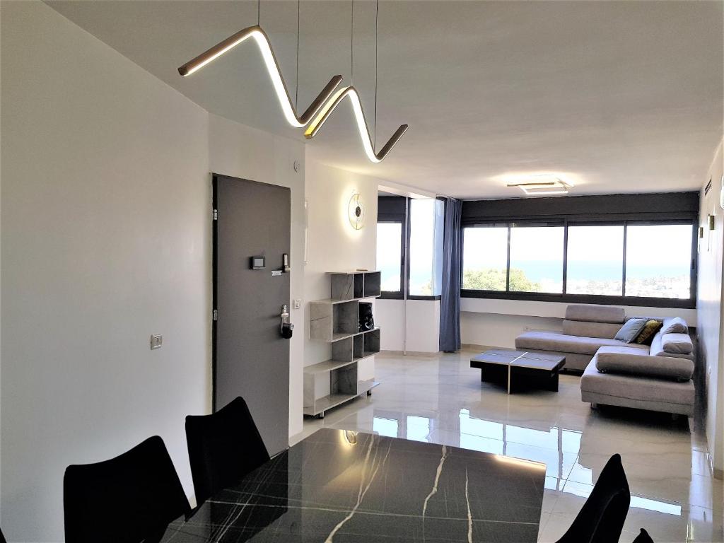 sala de estar con mesa y sofá en 4bdrm - 110mr - Dream vacation apartment en Tiberias