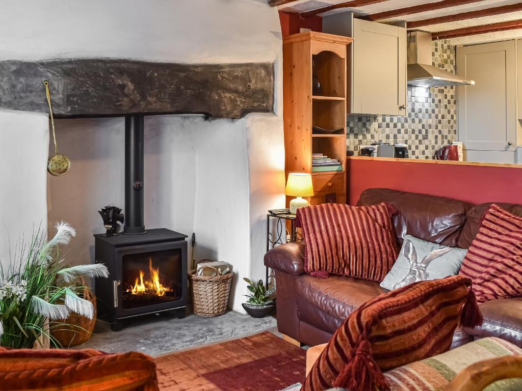 a living room with a couch and a fireplace at Ty Tarth in Pen-y-groes
