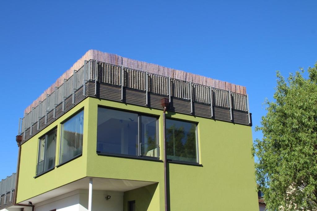 un edificio amarillo con una terraza encima en Azuria Schwarzwald Loft en Kappelrodeck