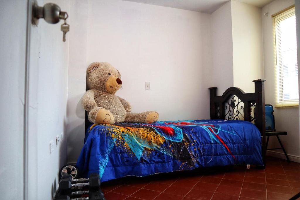 a teddy bear sitting on top of a bed at I am envigado. in Envigado