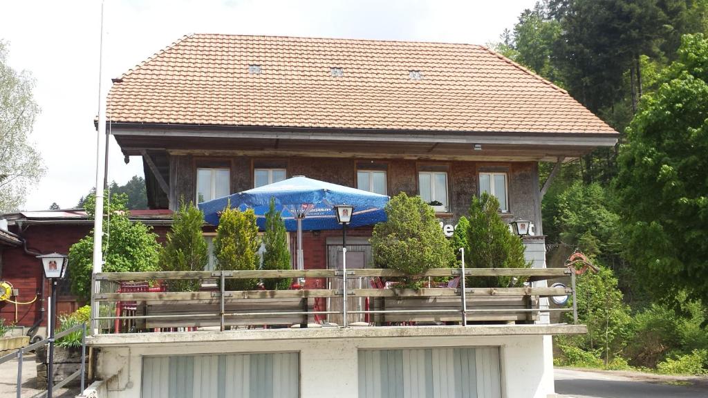 Cette maison dispose d'un balcon avec un parasol bleu. dans l'établissement Gastwirtschaft Hornbach-pinte, à Wasen