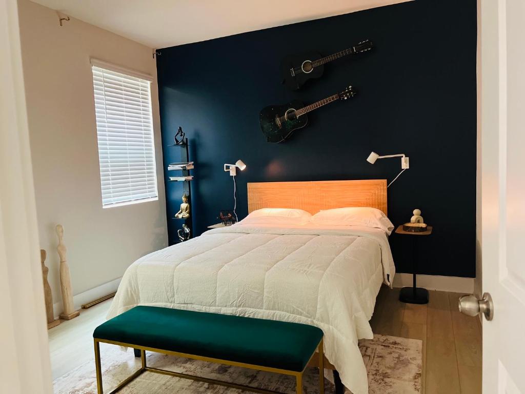 a bedroom with a bed with a guitar on the wall at Charlotte Comfort Haven in Charlotte