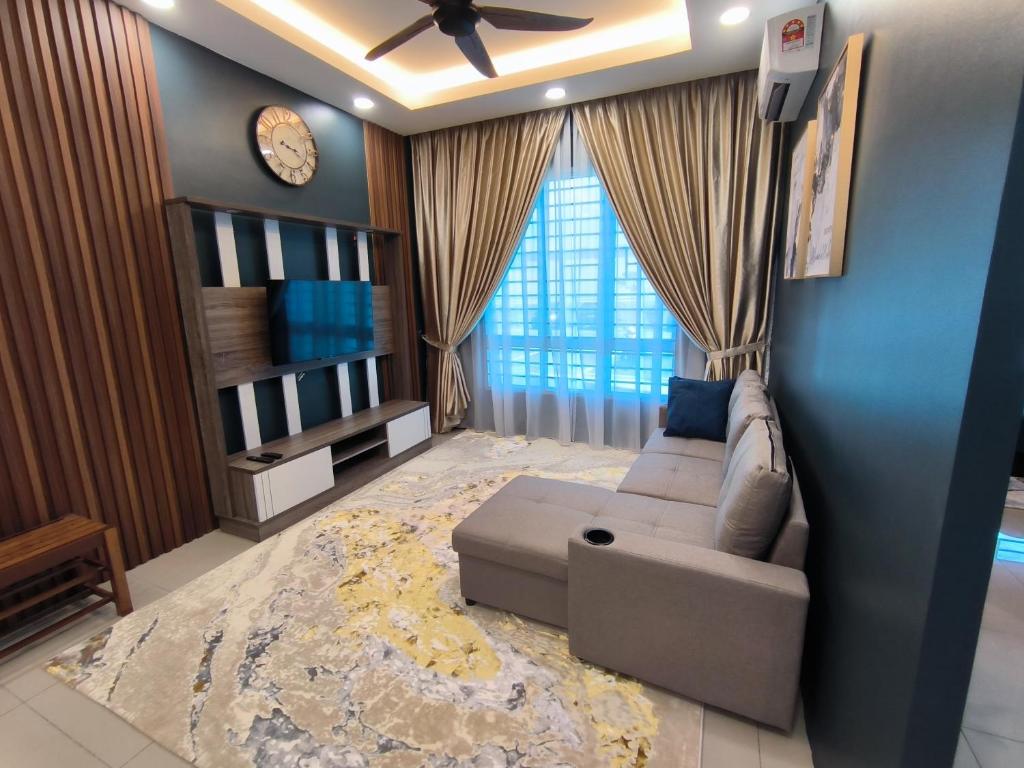 uma sala de estar com um sofá e um relógio na parede em Homestay Naufal Bandar Sri Sendayan Ground Floor em Seremban