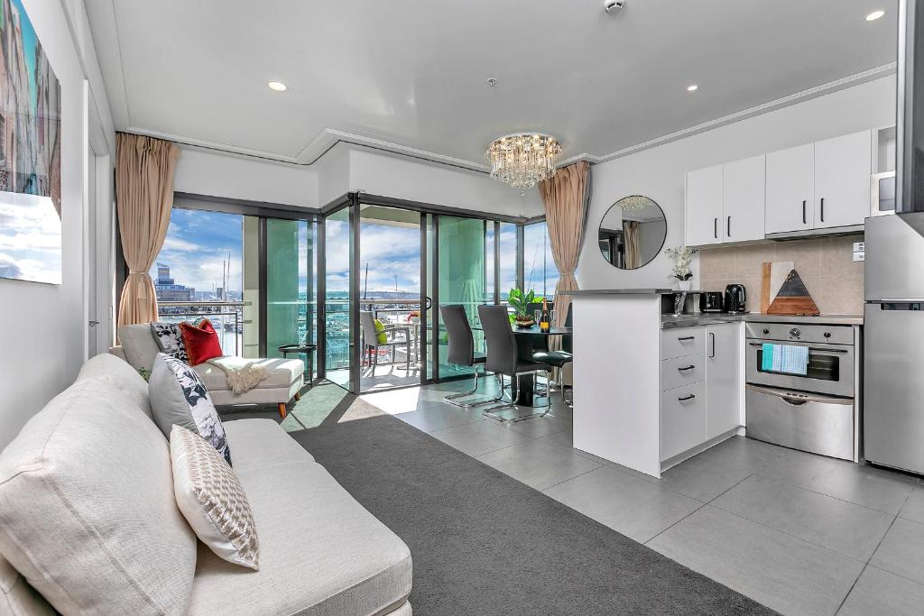 Il comprend un salon avec un canapé blanc et une cuisine. dans l'établissement Bachelor's Sunset Pad, à Auckland