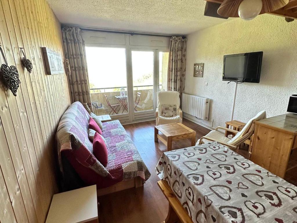 un salon avec un canapé et une télévision dans l'établissement Studio cosy avec balcon, pied des pistes de Villard-de-Lans - FR-1-515-178, à Villard-de-Lans