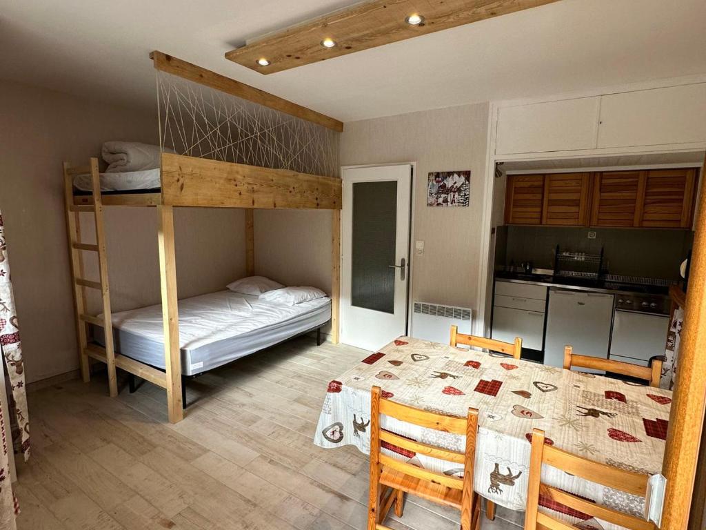 a bedroom with a bunk bed and a table and chairs at Studio Villard-de-Lans, 1 pièce, 4 personnes - FR-1-515-179 in Villard-de-Lans