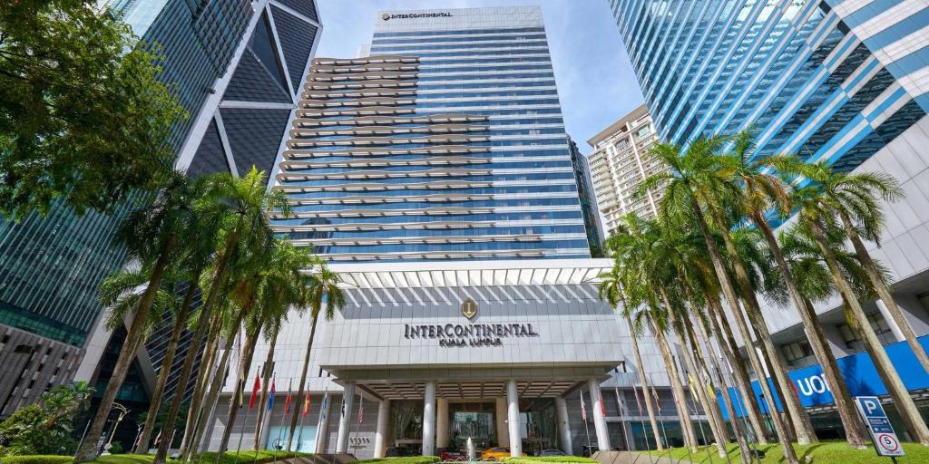 un edificio con palmeras frente a edificios altos en InterContinental Kuala Lumpur, an IHG Hotel en Kuala Lumpur