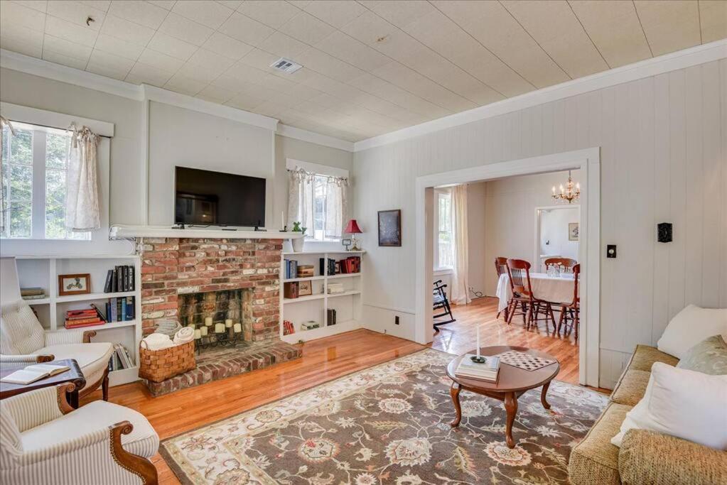 a living room with a fireplace and a table at Noble Cottage 3 Bed 1 Bath in Augusta