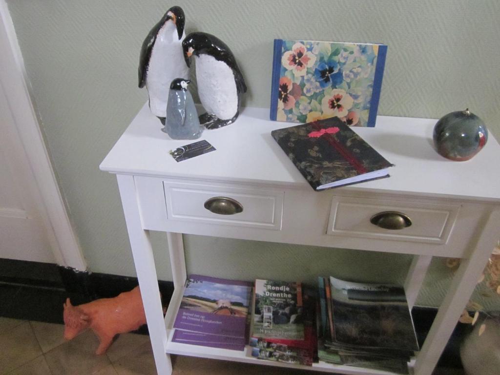 a white nightstand with books on top of it at B&B Beatrix in Beilen