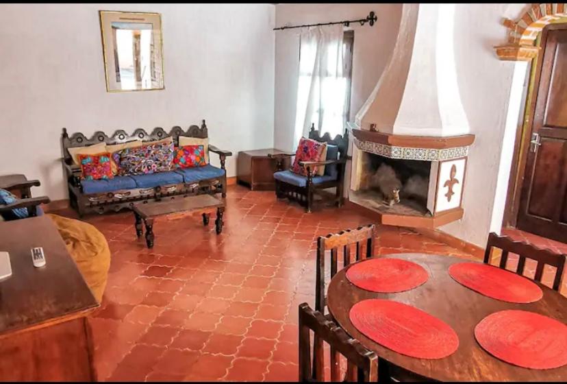 salon ze stołem i kominkiem w obiekcie Villa en San Miguel de Allende w mieście San Miguel de Allende