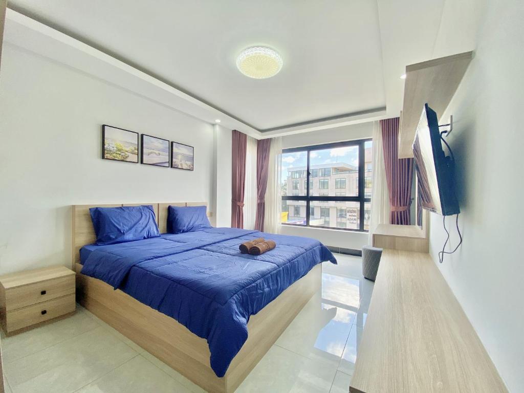 金邊的住宿－WH Chamkarmon Residence，一间卧室配有蓝色的床和电视