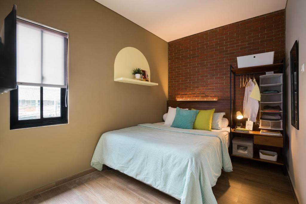 a bedroom with a bed and a brick wall at Cove W Suites in Jakarta