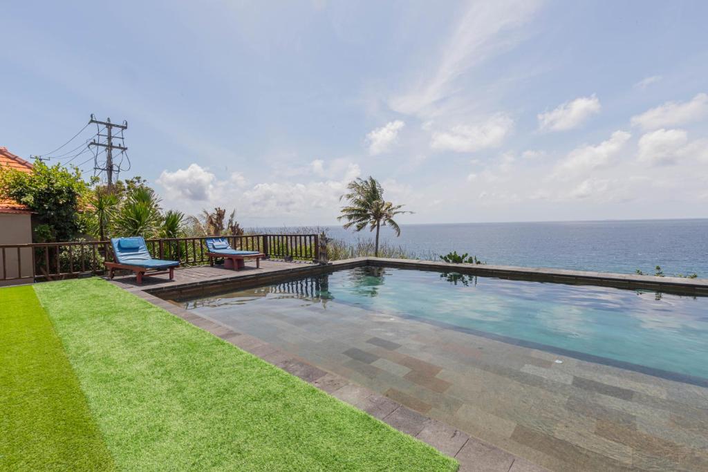 a swimming pool with a view of the ocean at Manta Cottages with Sea View in Nusa Penida