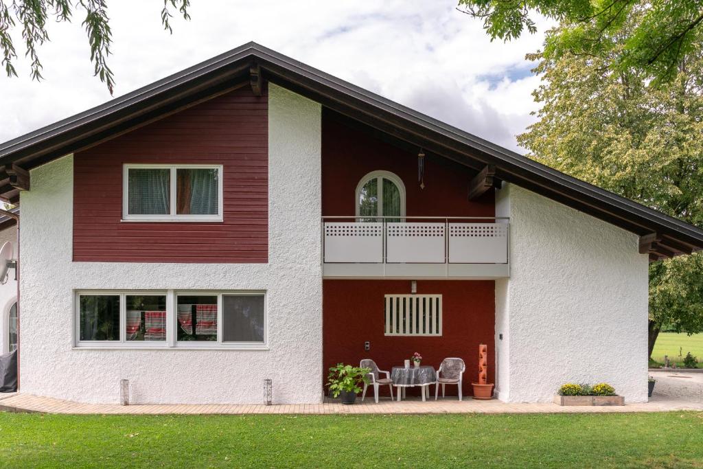 a white and red house with two chairs at Ferienwohnung Bichler in Altötting