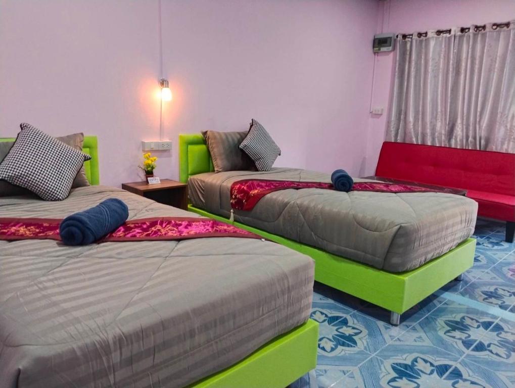 three beds in a room with red and green at SK Hometel Samui Airport in Bang Rak Beach