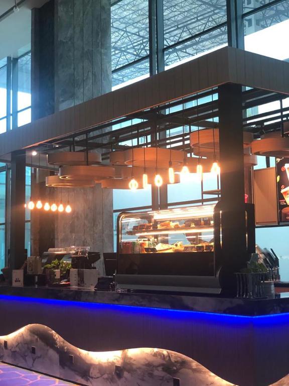 a restaurant with a counter with food in it at Anara Airport Hotel in Tangerang