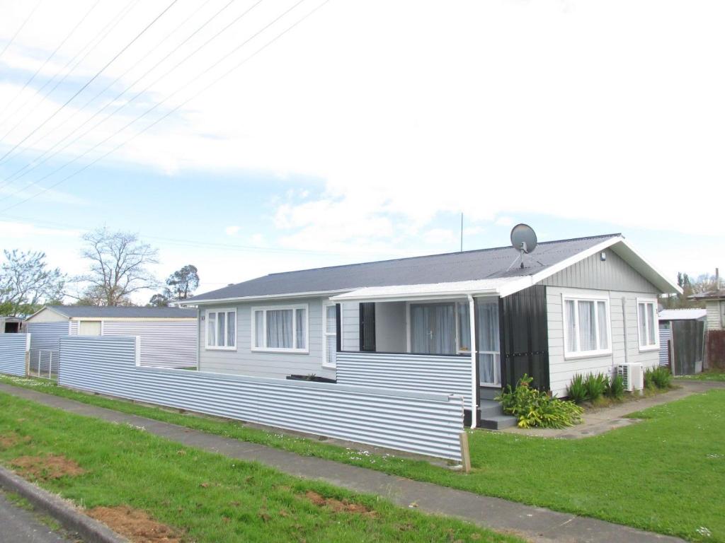 a white house with a black roof at The Mitch in Wairoa