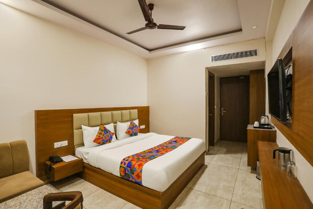 a bedroom with a bed and a flat screen tv at FabHotel Aman Sara in Lucknow