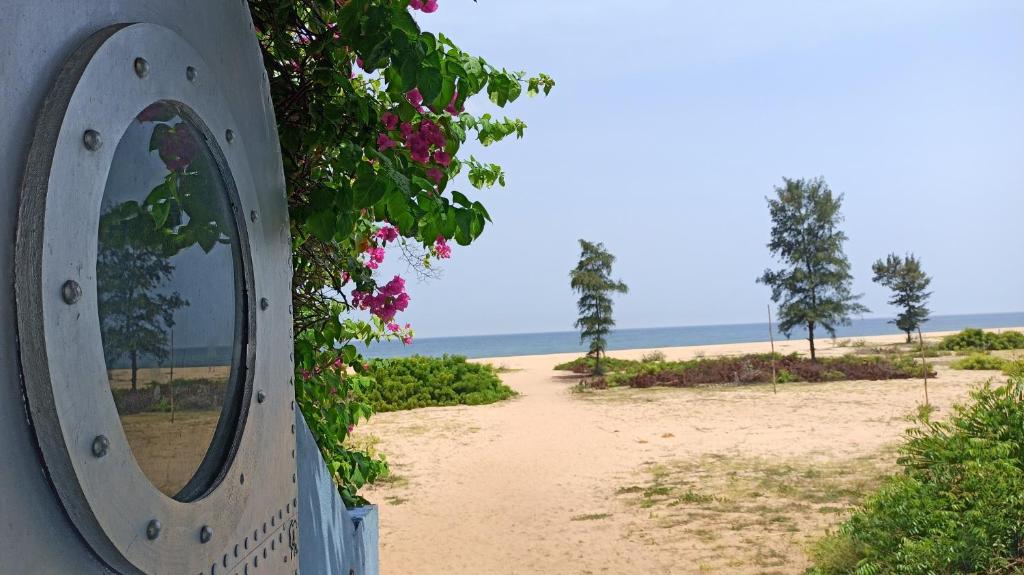 einen Spiegel an der Seite eines Gebäudes neben einem Strand in der Unterkunft The Dune Eco Village and Spa - Pondicherry in Puducherry