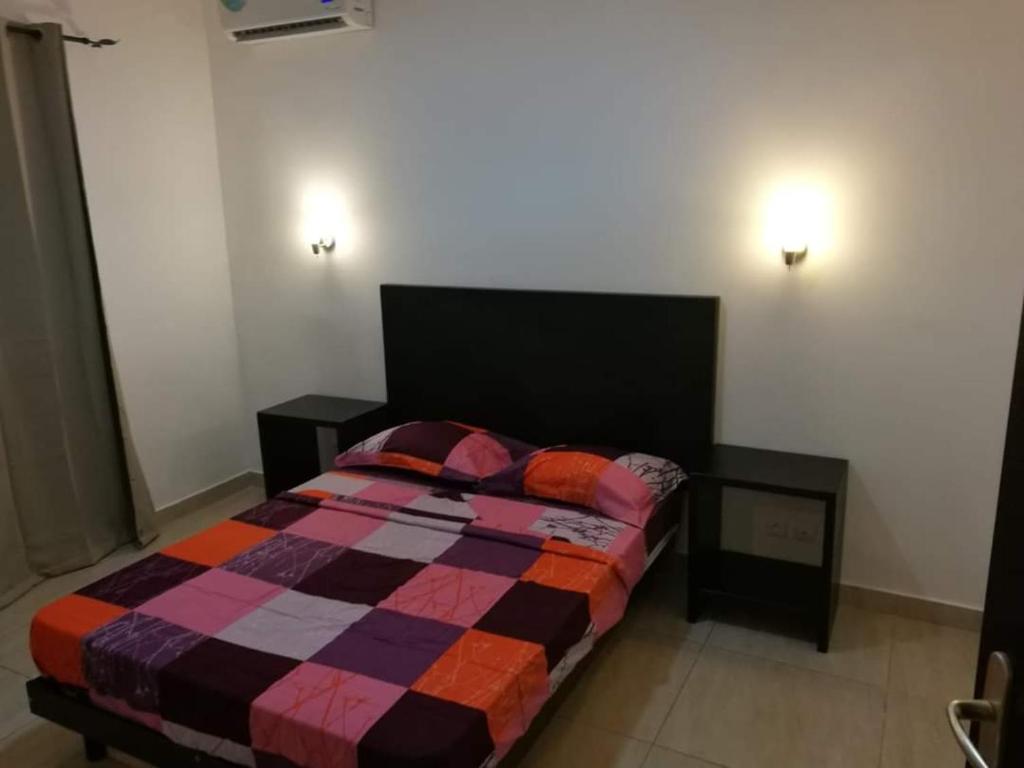 1 dormitorio con 1 cama con una manta colorida en Appartement coup de cœur en Pointe-Noire