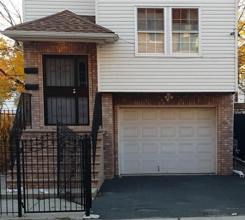 ein Haus mit einer Garage und einem Zaun in der Unterkunft 500 Estates LLC in Irvington
