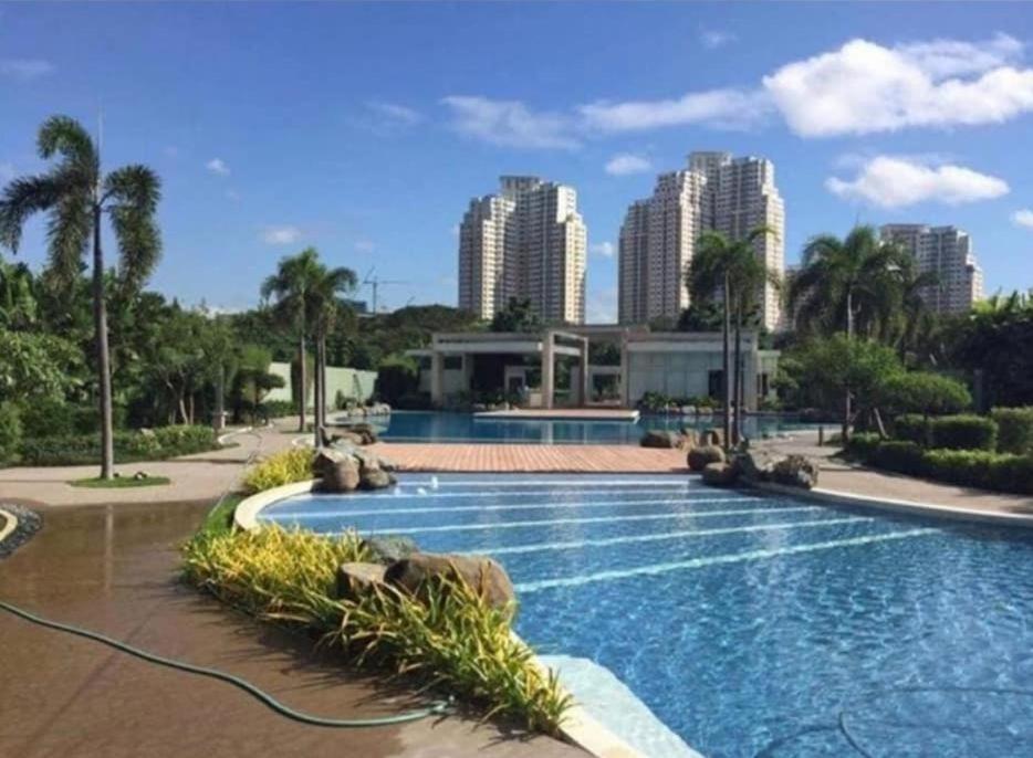 een zwembad met een stad op de achtergrond bij Casa REYNA at KASARA Urban Residences in Manilla