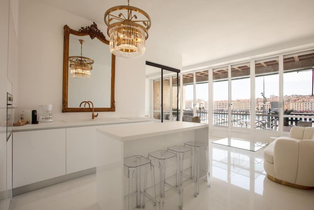 - une cuisine blanche avec un comptoir et un miroir dans l'établissement LUXE SUR LE PORT, à Marseille
