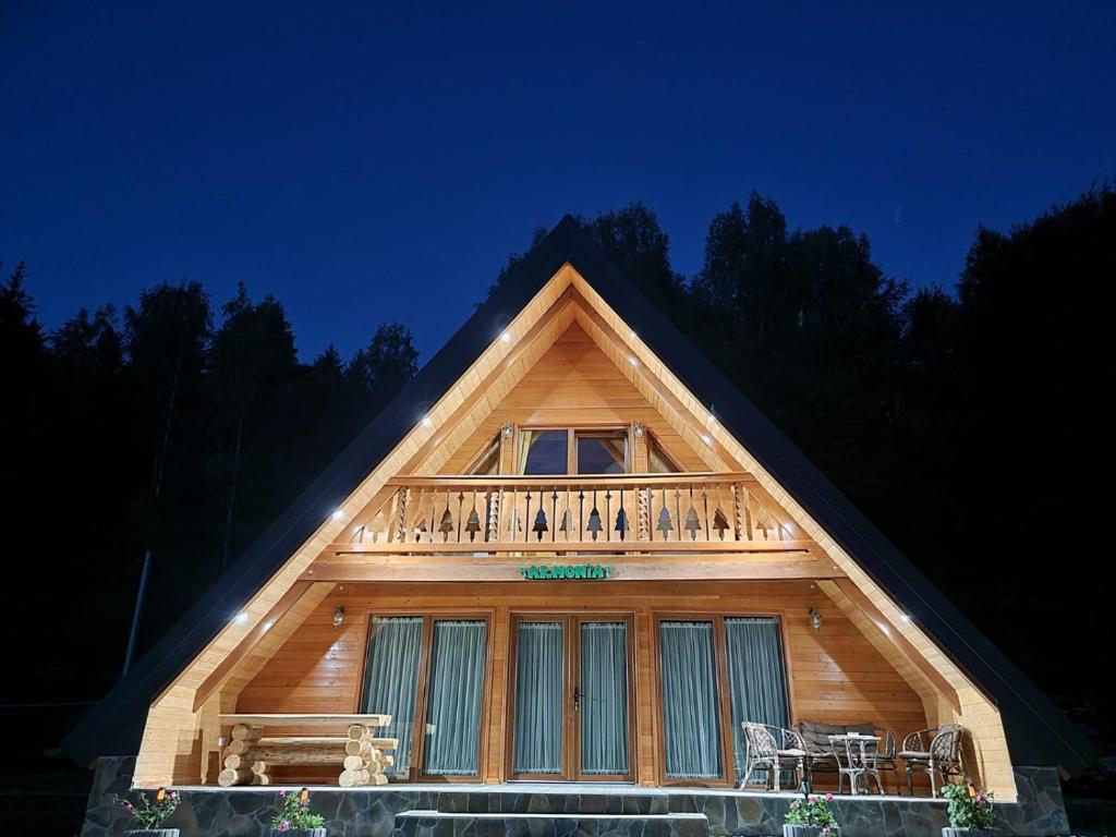 ein Holzhaus mit Balkon darüber in der Unterkunft Casuta Armonia in Moisei