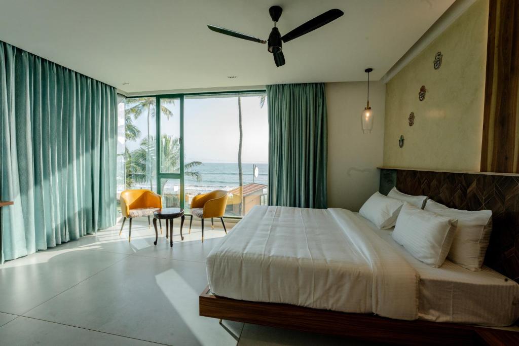 een slaapkamer met een bed en uitzicht op de oceaan bij ANANSA BOUTIQUE HOTEL by The Kannur Club in Kannur