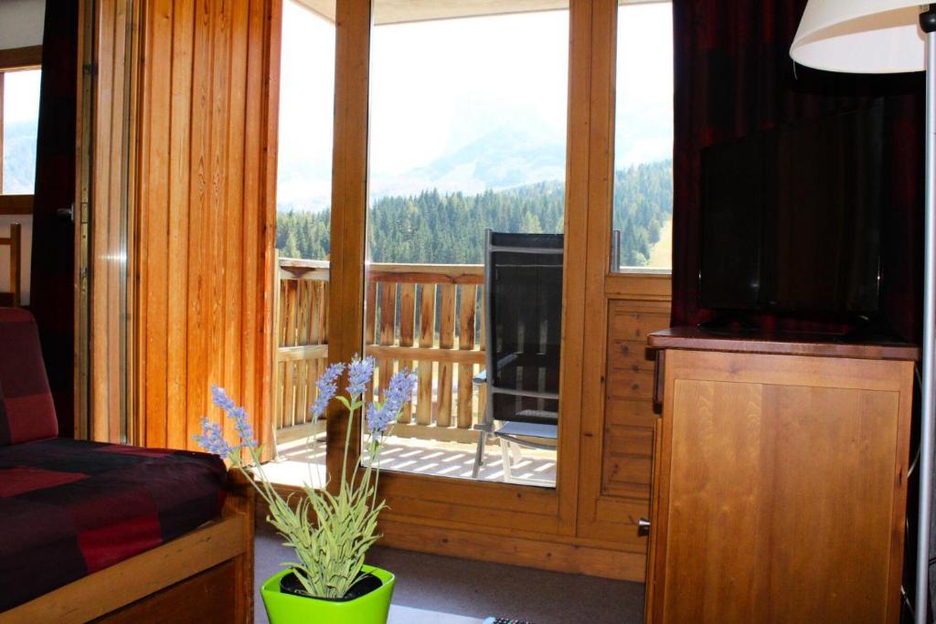 - un salon avec une télévision et une terrasse couverte dans l'établissement Résidence Les Toits Du Devoluy - APPARTEMENT 6 PERSONNES BALCON EXPO SUD MAE-8604, à Saint-Étienne-en-Dévoluy