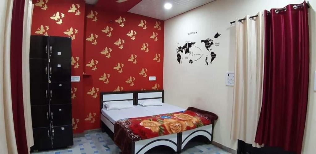 um quarto com uma cama e uma parede vermelha em Blue eye Backpackers Hostel em Amritsar