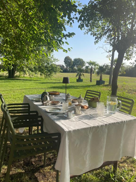 Une table blanche avec de la nourriture dans un champ dans l'établissement Villa Leopardi, à Vignale