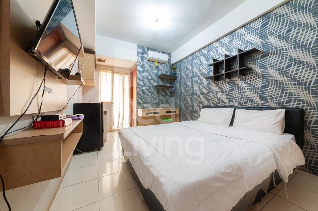 una camera con letto e TV a parete di RedLiving Apartemen Green Lake View Ciputat - Aurora Rooms a Pondokcabe Hilir