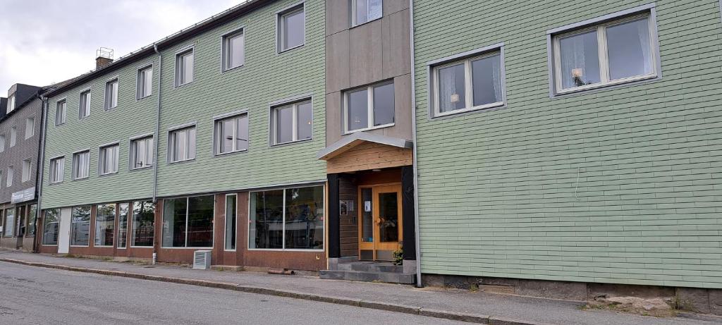 un edificio verde al lado de una calle en Kramfors Stadshotell AB en Kramfors