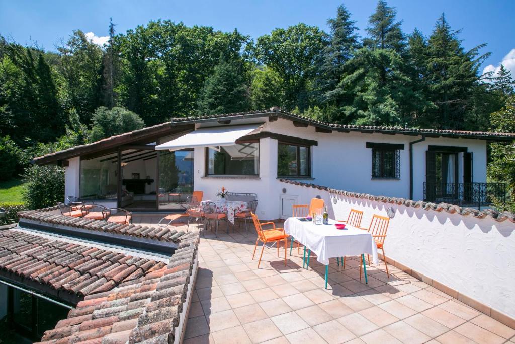 una casa y un patio con mesa y sillas en Villa Blu Ortensia - Happy Rentals en Pura