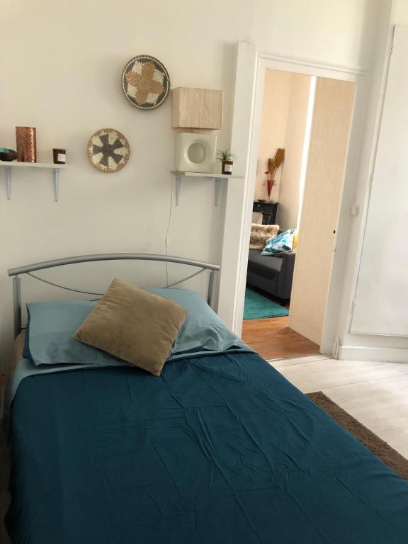 - une chambre dotée d'un lit bleu et d'une horloge murale dans l'établissement Appt à Blois : Art et Histoire !, à Blois