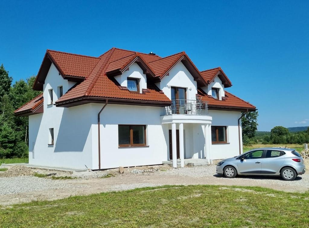 a house with a car parked in front of it at Niebo nad Łysicą in Święta Katarzyna